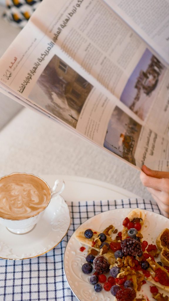 Cozy morning with a cup of coffee and berries while reading a newspaper.